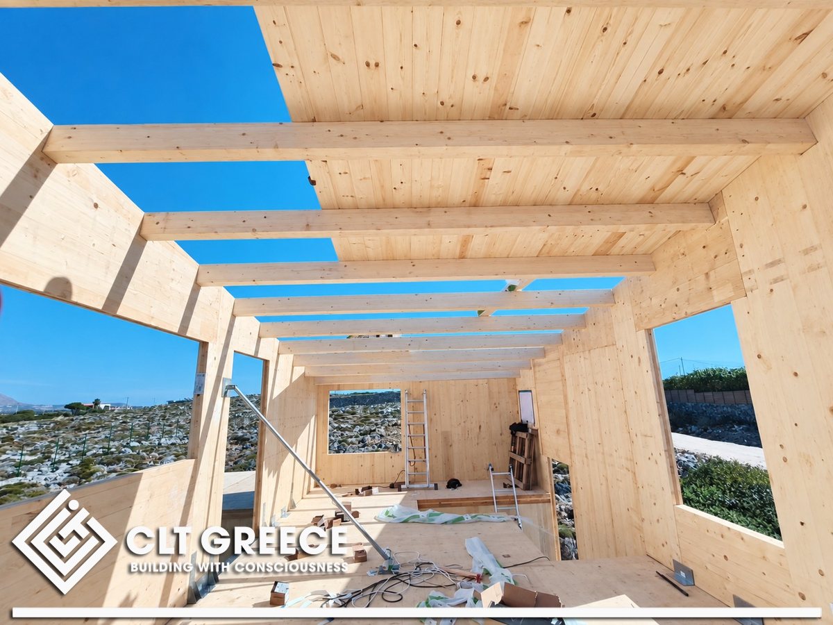 The upper floor of the CLT house with its roof beams and openings to the landscape